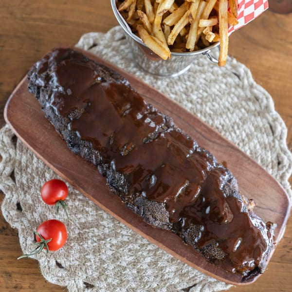 Smoke Shack BBQ ribs with sauce, two cherry tomatoes, and a bucket of fries.